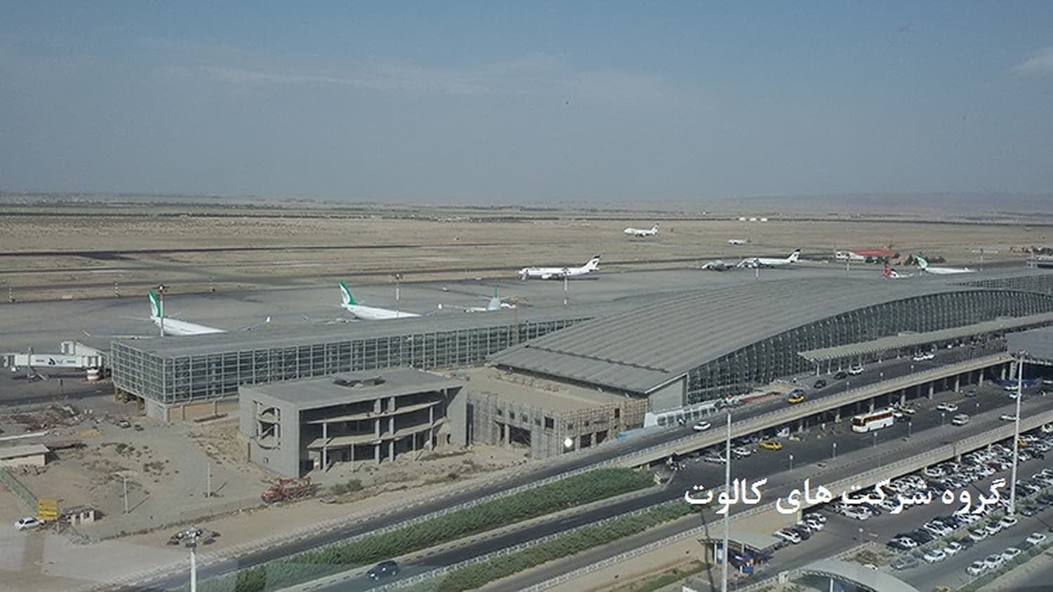 دو بخش ترمینال فرودگاه با سقف فلزی و هواپیماهای مسافربری روی اپرون