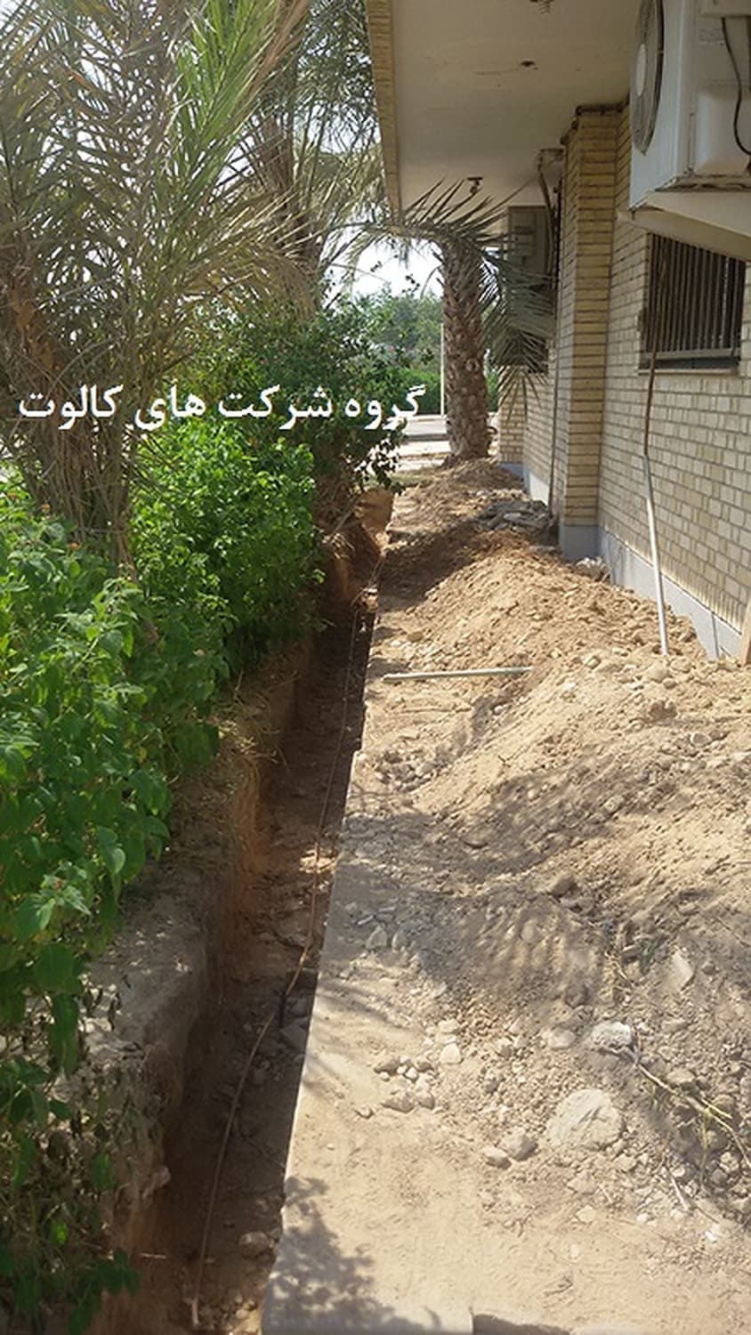 کانال حفاری‌شده برای هادی ارت در امتداد دیوار ساختمان و کنار درختچه‌ها