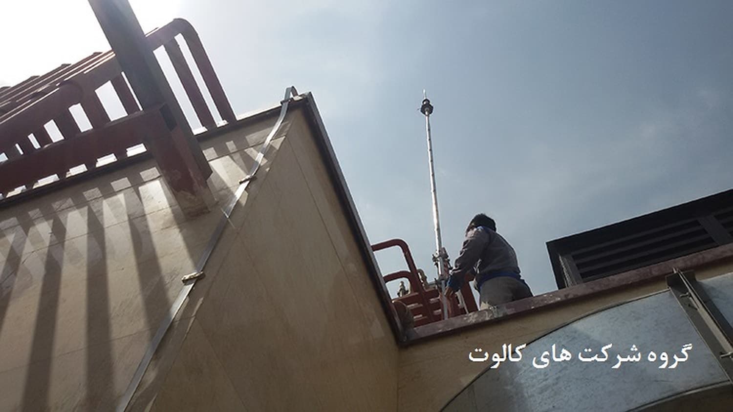 تکنسین در حال نصب صاعقه‌گیر الکترونیکی (ESE) روی دکل در بام ساختمان