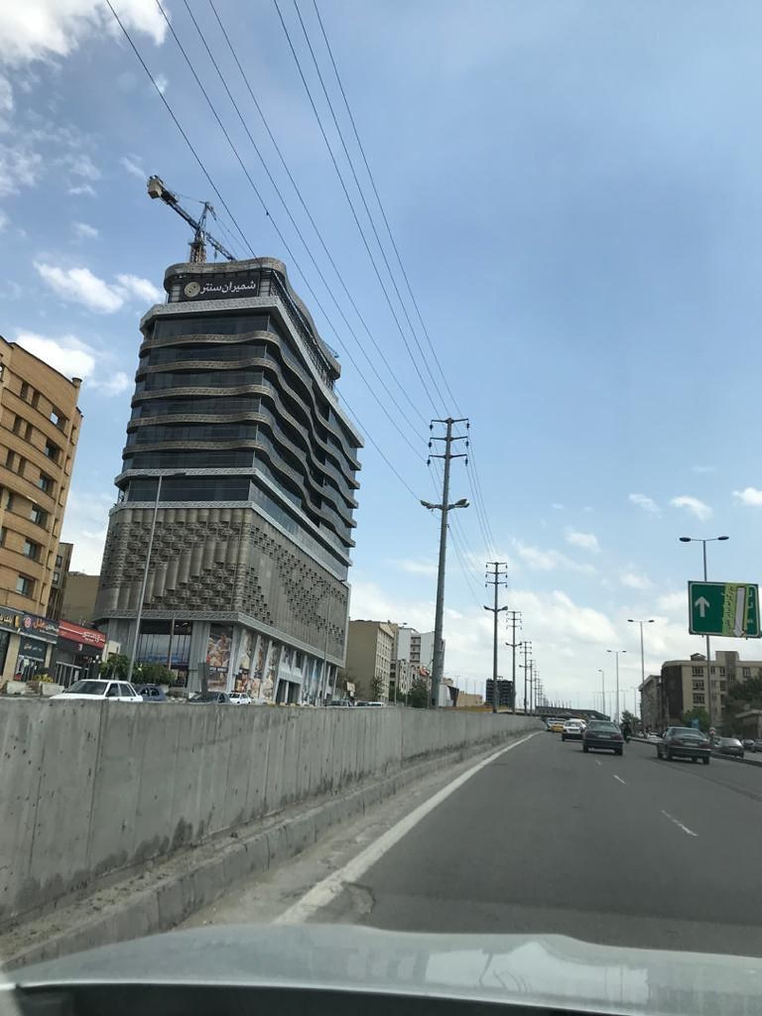 ساختمان بلند در حال ساخت با جرثقیل، از بزرگراه