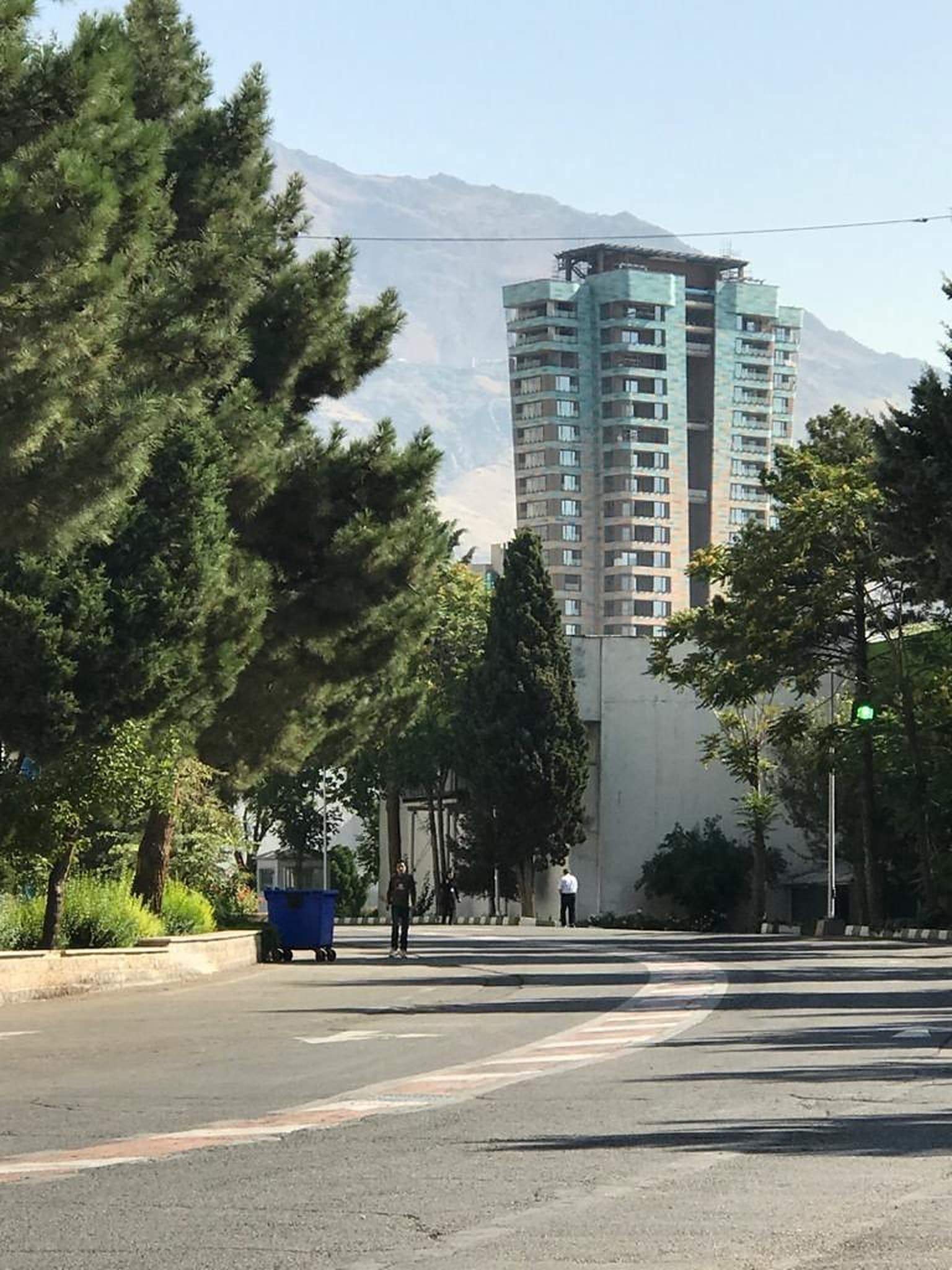 برج مسکونی مهرآفرین از خیابان با کوه در پس‌زمینه