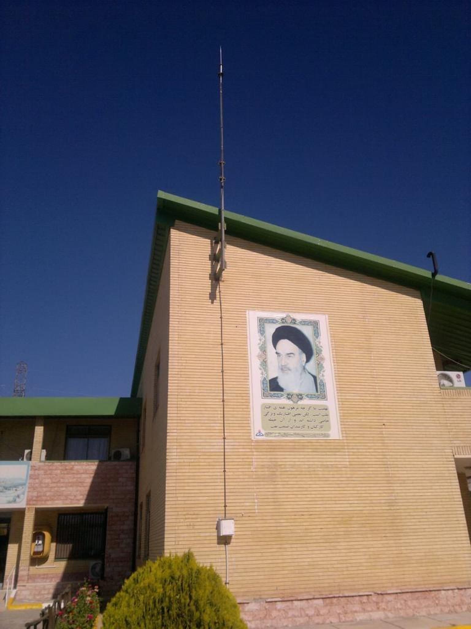 ساختمان آجری مدرسه با دکل صاعقه‌گیر بلند
