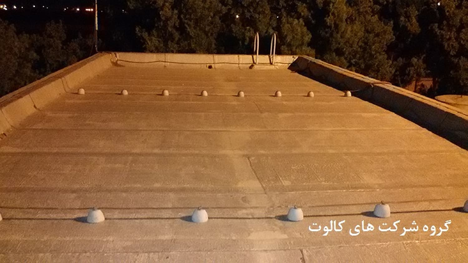 ردیف پایه‌های بتنی هادی روی بام وسیع در نور شب