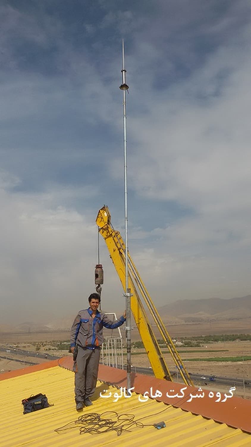 برپایی دکل صاعقه‌گیر بلند روی بام با جرثقیل زرد