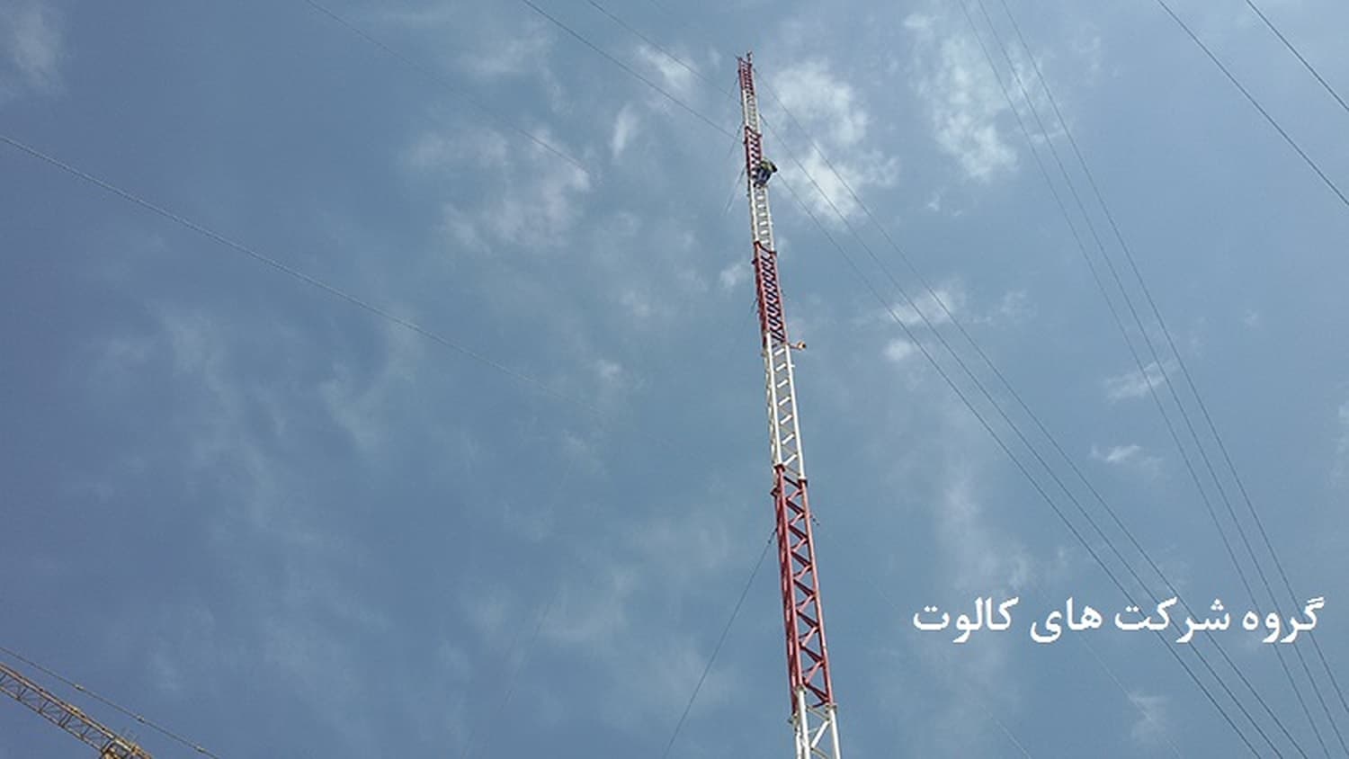 دکل مخابراتی مشبک قرمز و سفید در آسمان